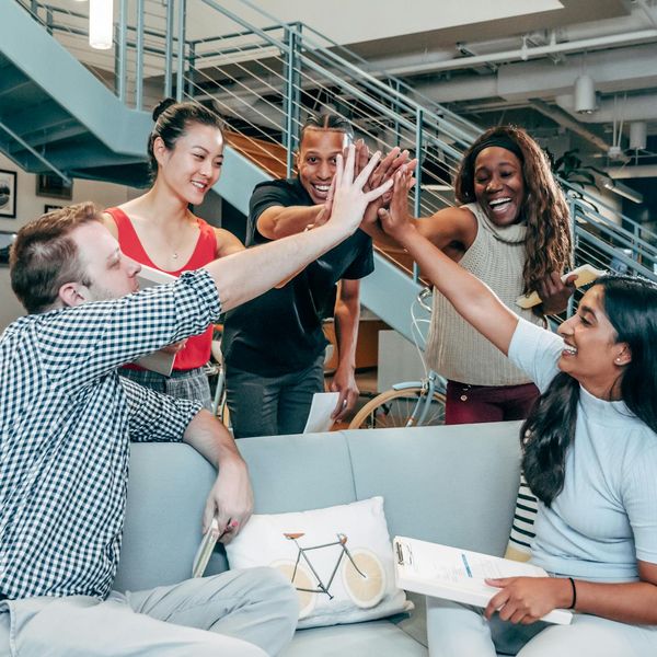 A diverse group of smiling office workers in a modern workspace.